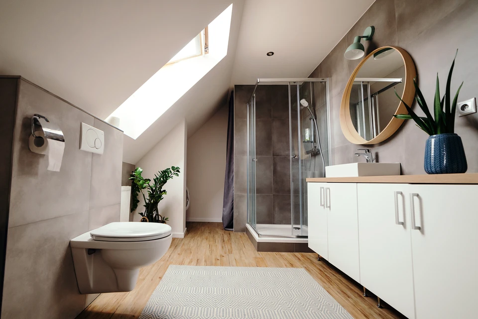 Salle de bain moderne sous combles avec douche à l'italienne, WC suspendu et meuble vasque blanc